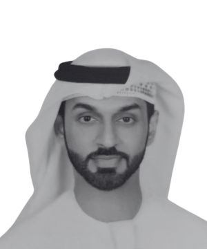 A black-and-white headshot of a bearded man wearing a keffiyeh and traditional clothing, evoking the timeless elegance of Dubai.